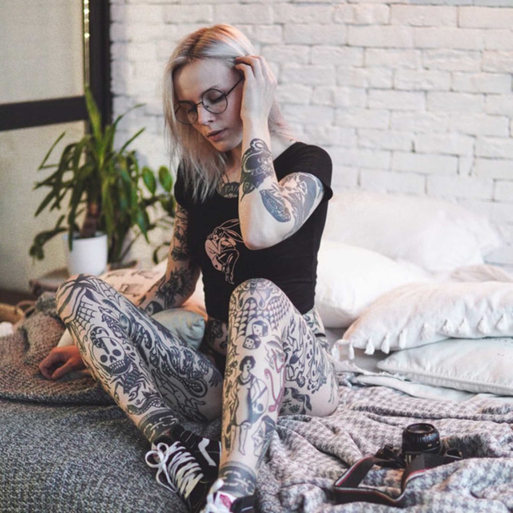 Lady on Bed with Tattoos | Numb. Tattoo Numbing Cream